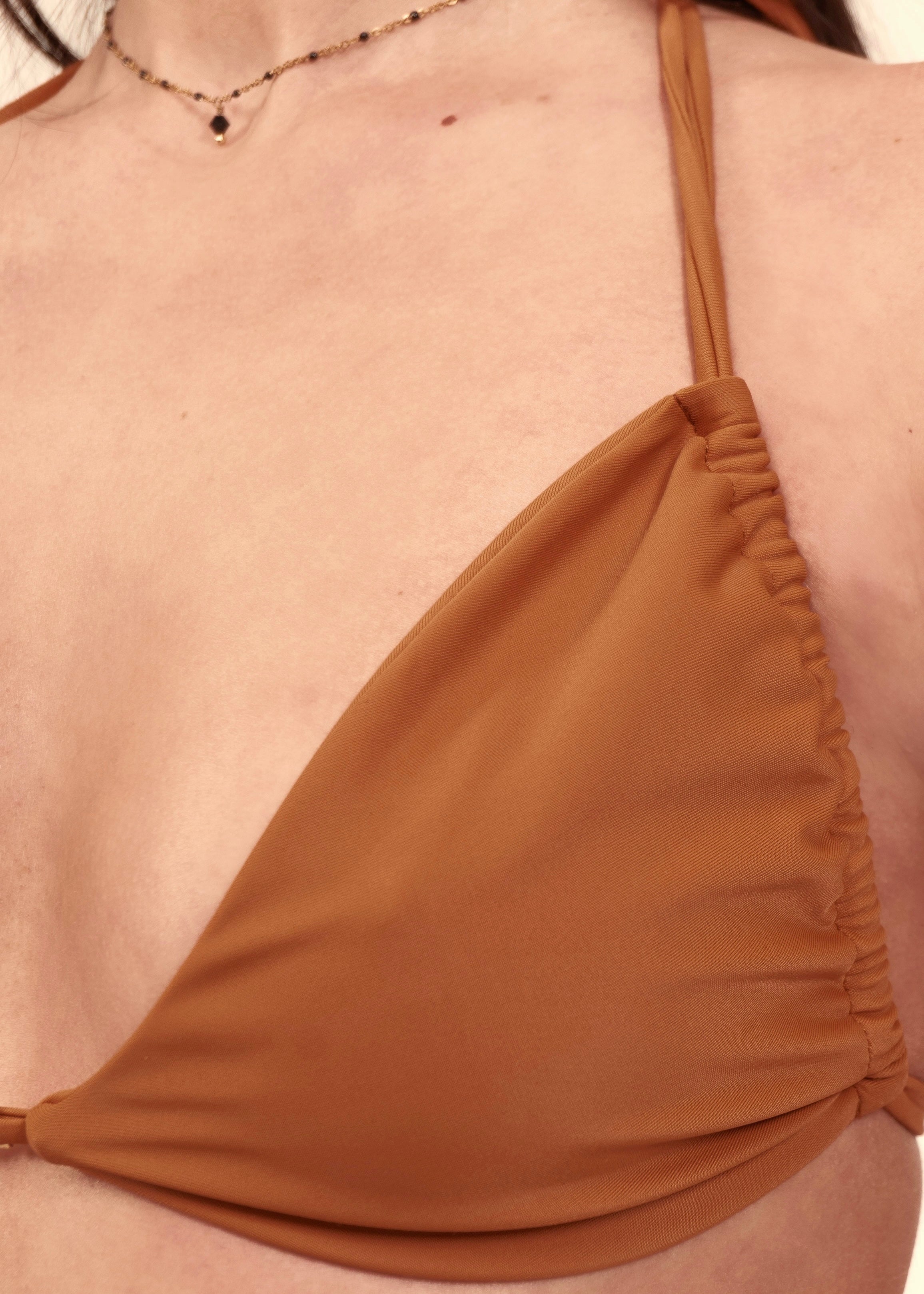 Close-up of the draped fabric and triangle cup construction on the May Rose Chia Patchouli camel bralette bikini top
