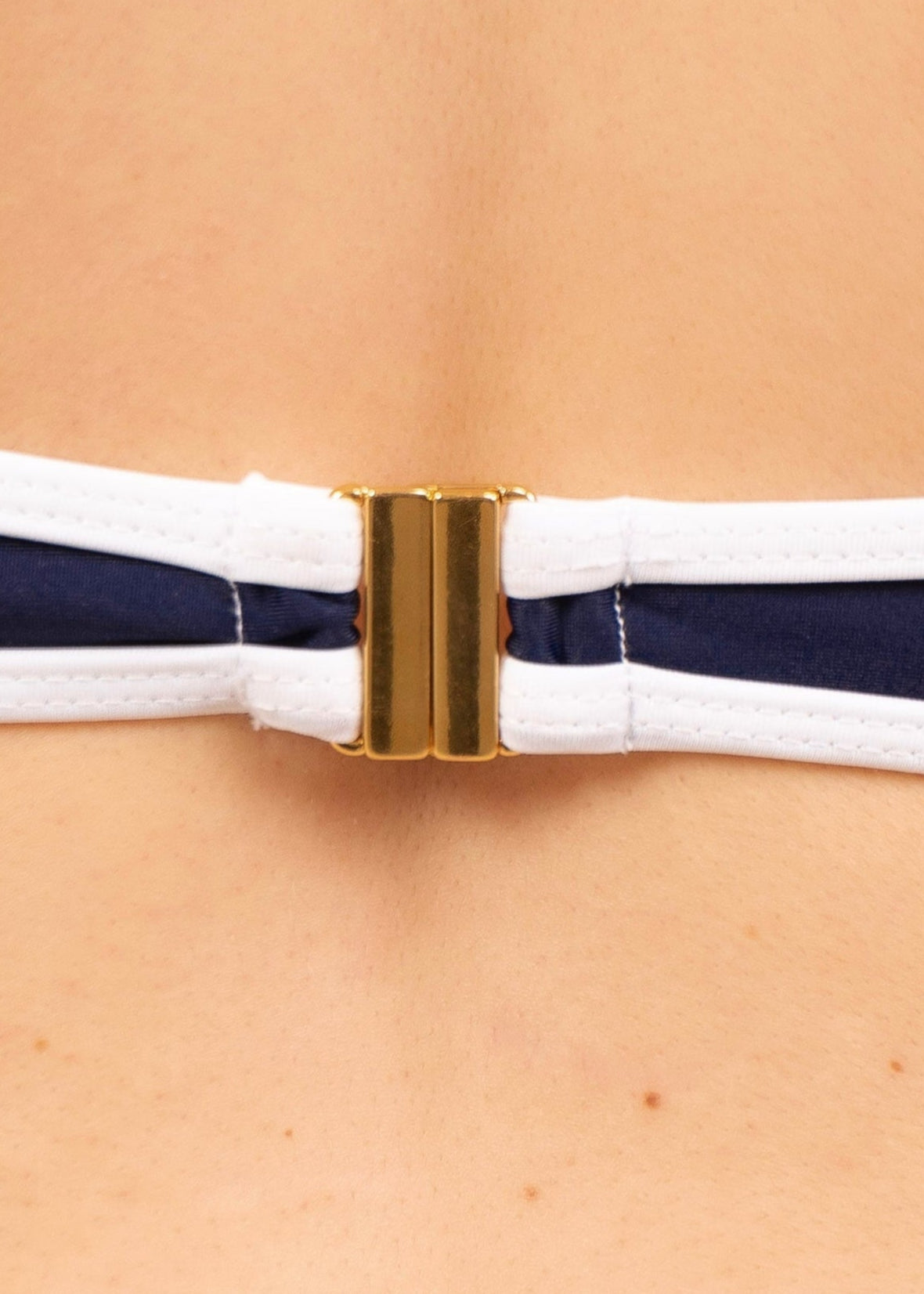 Close-up of the 18K gold-plated clip fastening on the May Rose Noah Sea Service navy and white bikini top
