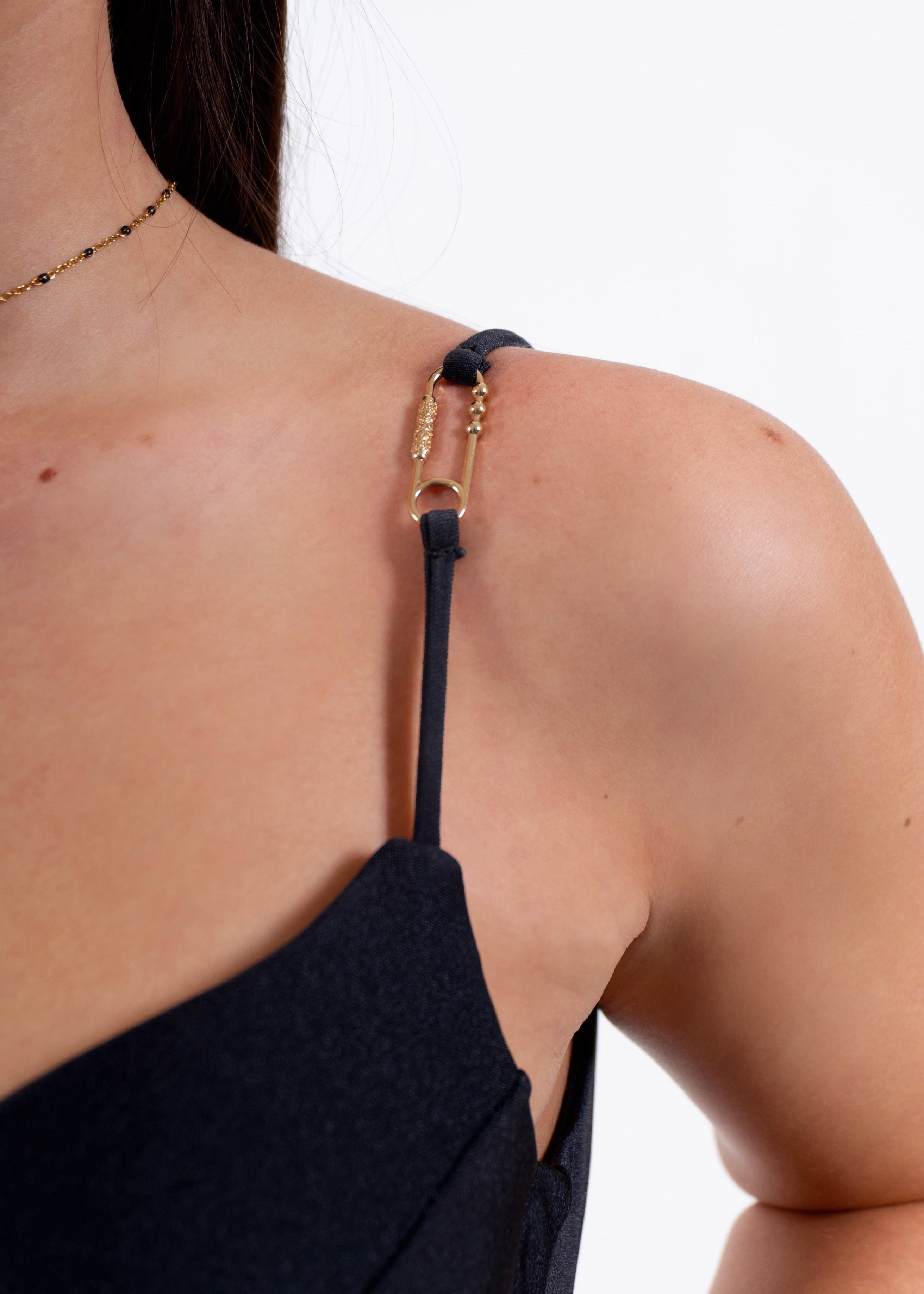 Close-up of the adjustable strap and 18K gold-plated safety pin charm on the May Rose Sereina Ebène black one-piece swimsuit