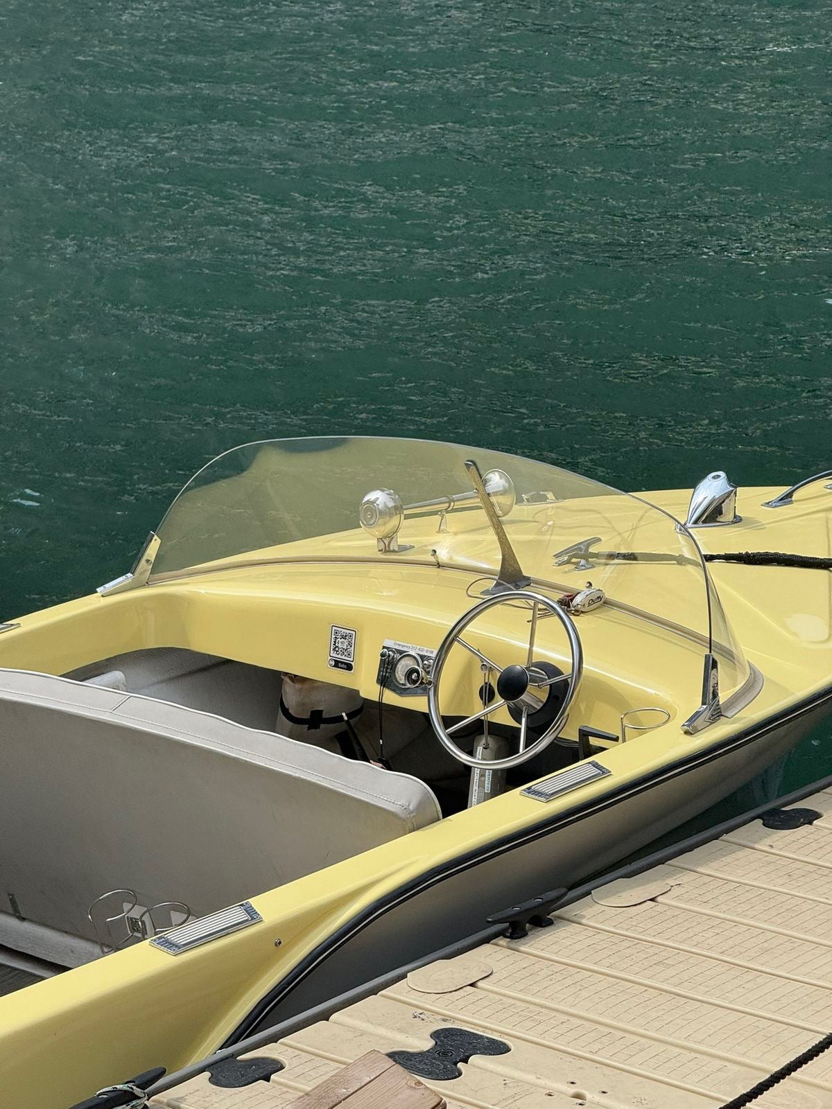 vintage yellow speedboat docked on turquoise water, luxury summer lifestyle.